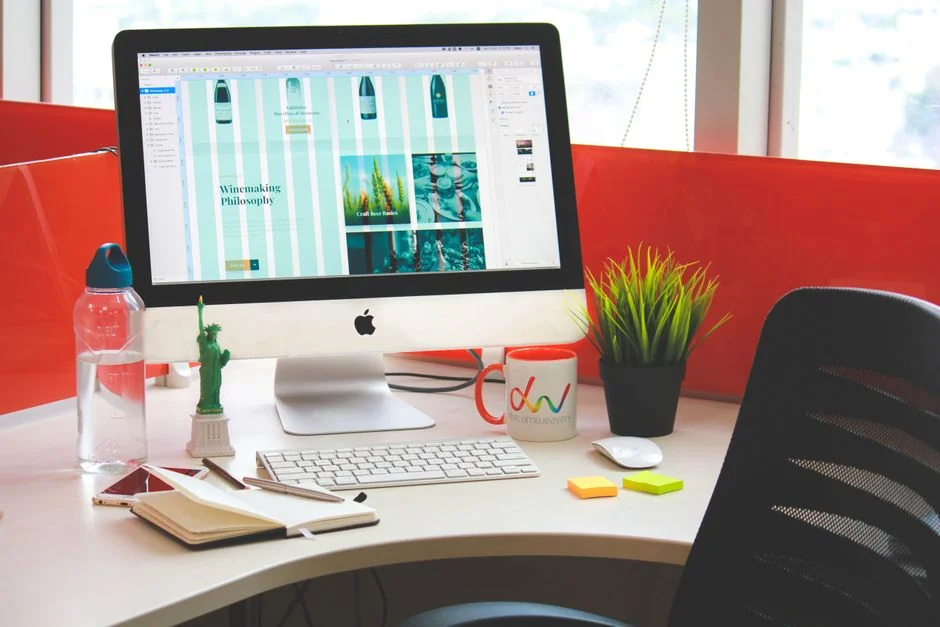 Deux écrans posés sur un bureau, illustrant la conception web dans un environnement de bureau moderne.